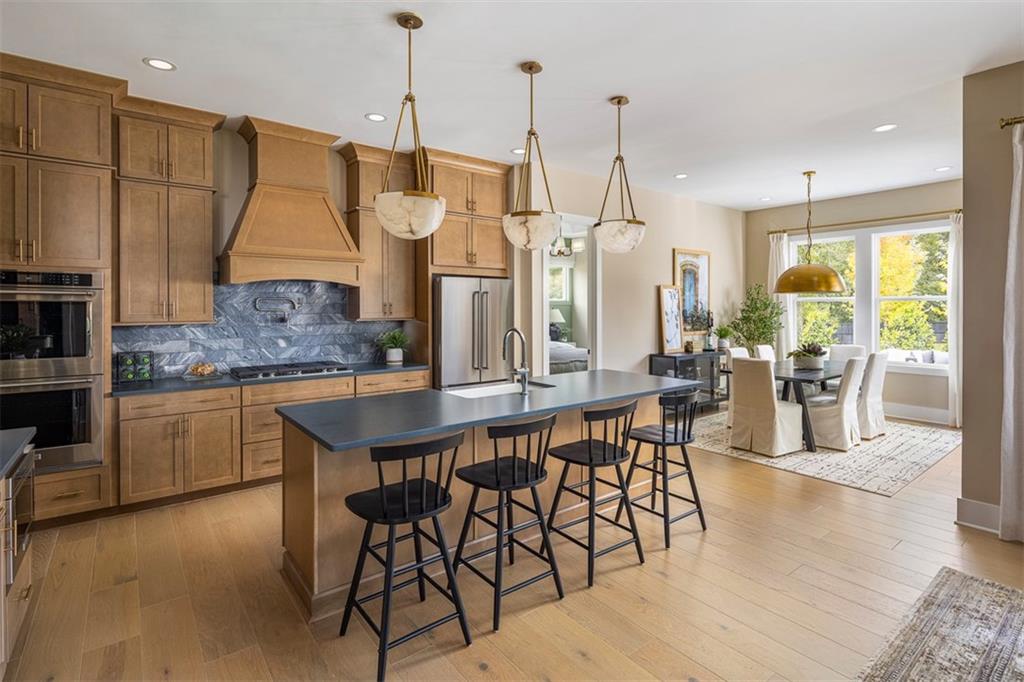 214 Mooney Road Woodstock, GA 30188 - Photo 3 of 17 a kitchen with stainless steel appliances granite countertop table chairs sink and stove