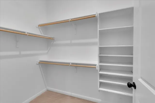 a view of walk in closet with empty racks