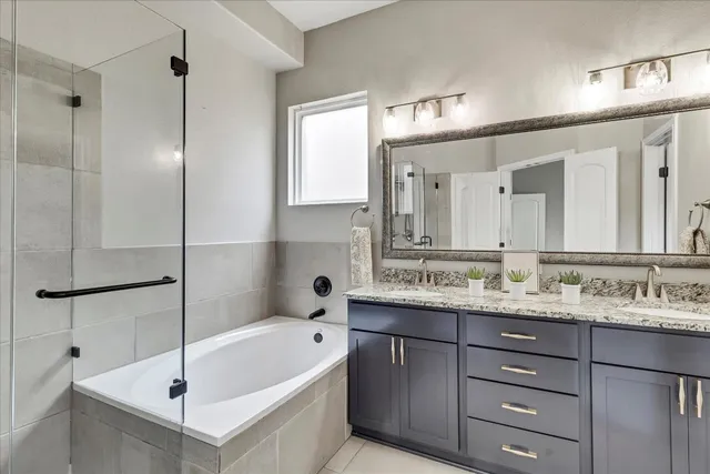 a bathroom with a tub a sink and mirror