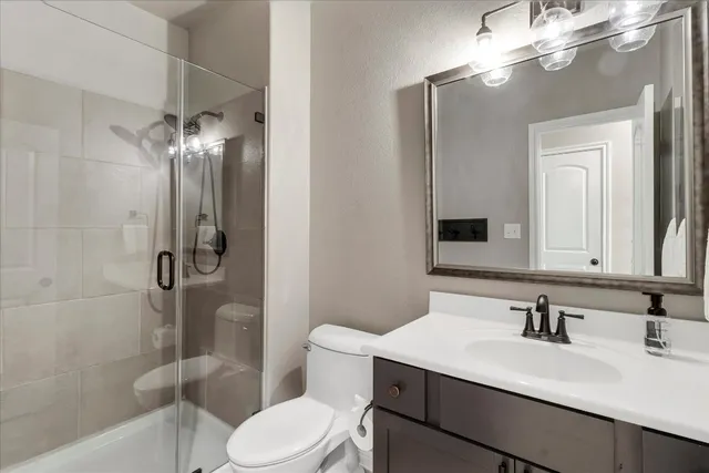 a bathroom with a sink vanity mirror and toilet