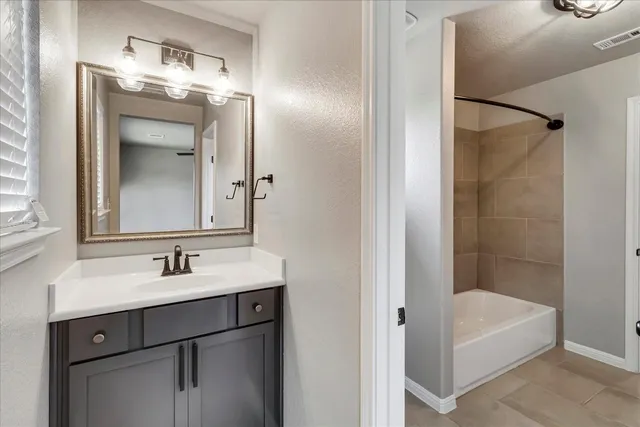 a bathroom with a tub sink and mirror
