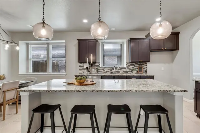 a kitchen with kitchen island granite countertop wooden floor cabinets and dining table