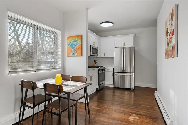 a kitchen with stainless steel appliances wooden floor and a refrigerator