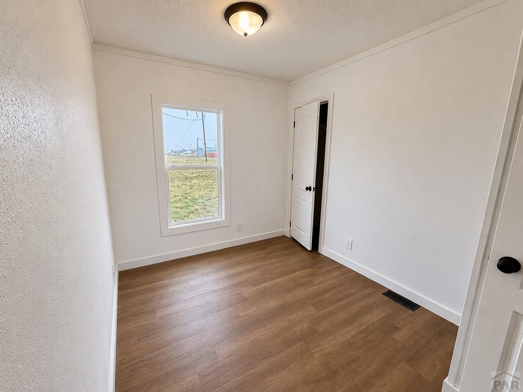 6652 County Rd HH.5 Lamar, CO 81052 - Photo 18 of 22 an empty room with wooden floor cabinet and windows
