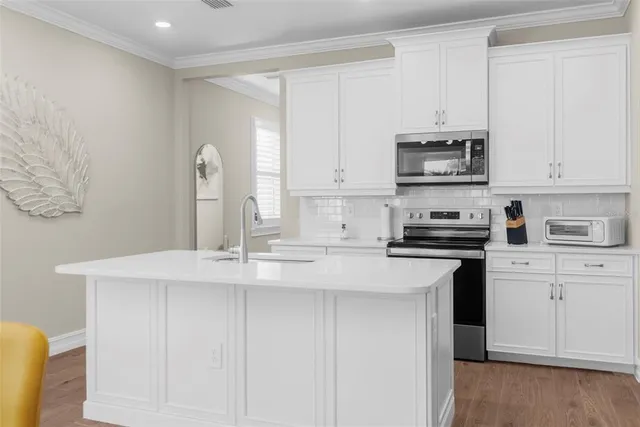 a kitchen with stainless steel appliances a sink a stove a microwave and cabinets