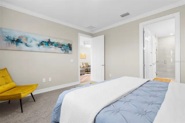 a bedroom with a bed a couch and a painting on the wall