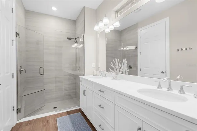 a bathroom with a double vanity sink mirror and shower