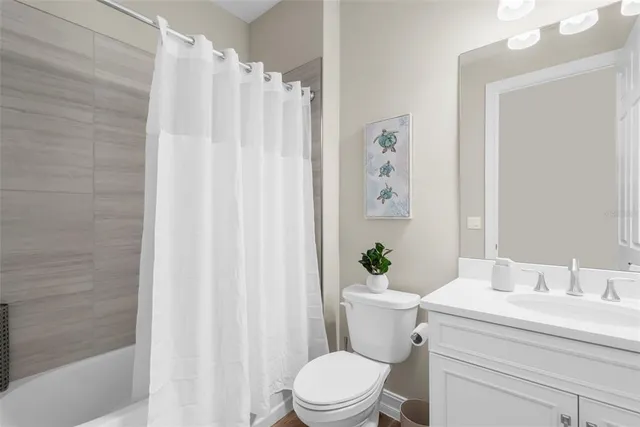 a bathroom with a sink a toilet and shower curtain