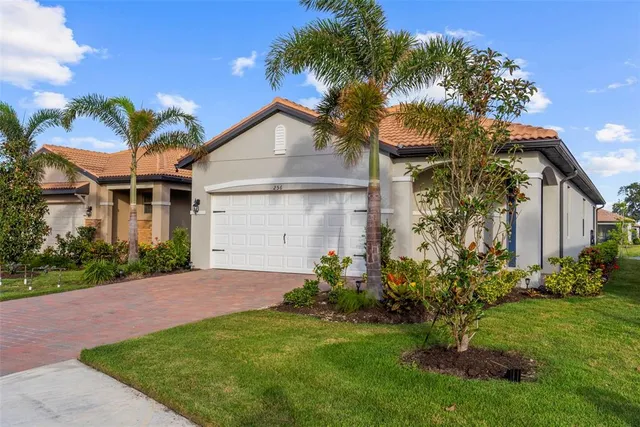 a front view of a house with a garden and plants