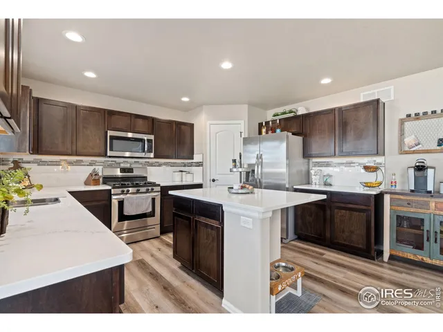 a kitchen with kitchen island granite countertop a stove sink microwave and refrigerator
