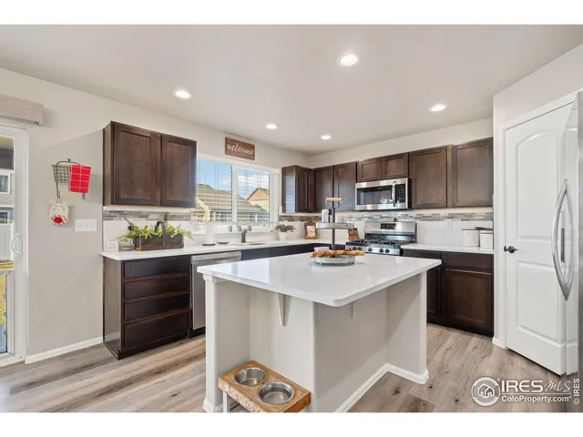 a kitchen with kitchen island sink stove and refrigerator