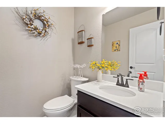 a bathroom with a sink vanity mirror and toilet