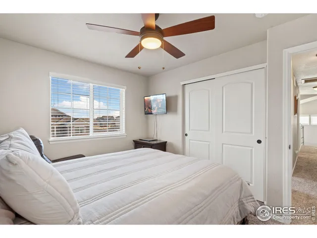 a bedroom with a bed and a large window
