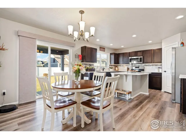 a view of a dining room and livingroom with furniture wooden floor a chandelier