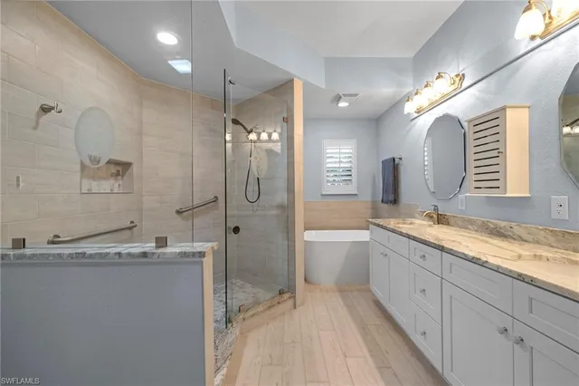 a spacious bathroom with a granite countertop sink mirror and a bath tub