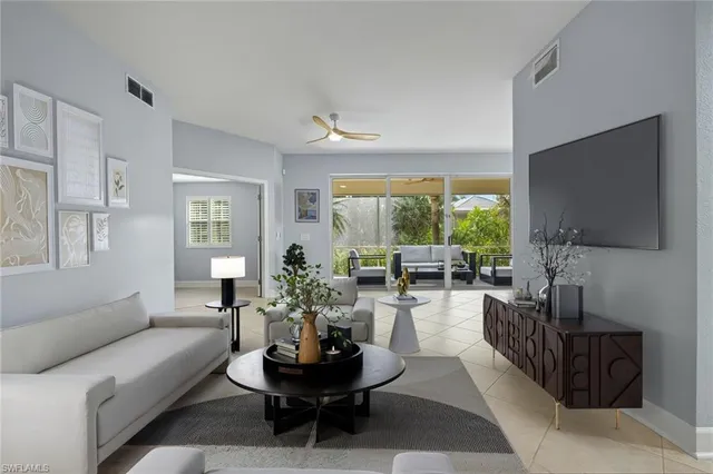 a living room with furniture a flat screen tv and a large window