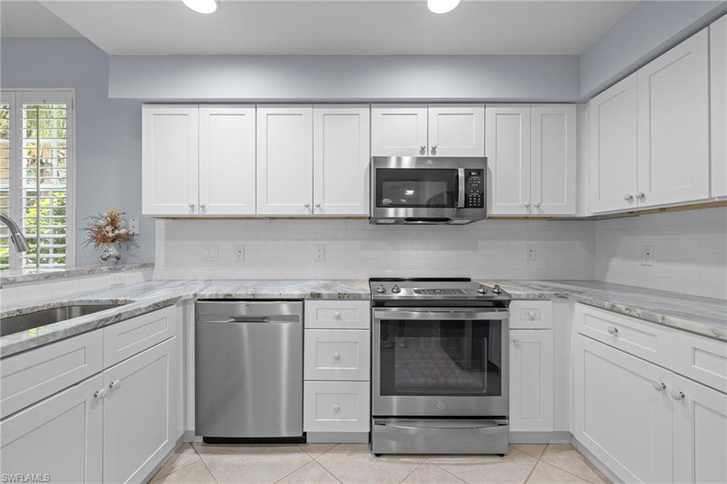 19081 Ridgepoint Drive, Unit 102 Estero, FL 33928 - Photo 3 of 50 a kitchen with white cabinets and appliances