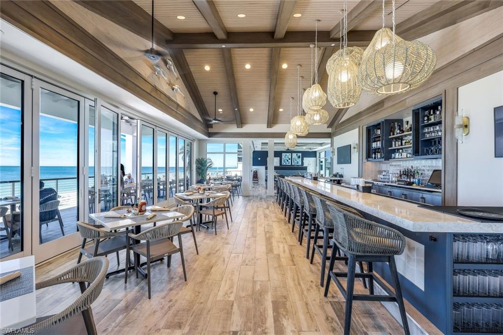 19081 Ridgepoint Drive, Unit 102 Estero, FL 33928 - Photo 33 of 50 a dining room with lots of wooden furniture and large windows