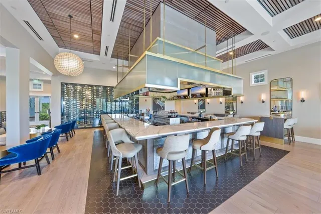 a dining room with stainless steel appliances granite countertop a table chairs and a chandelier