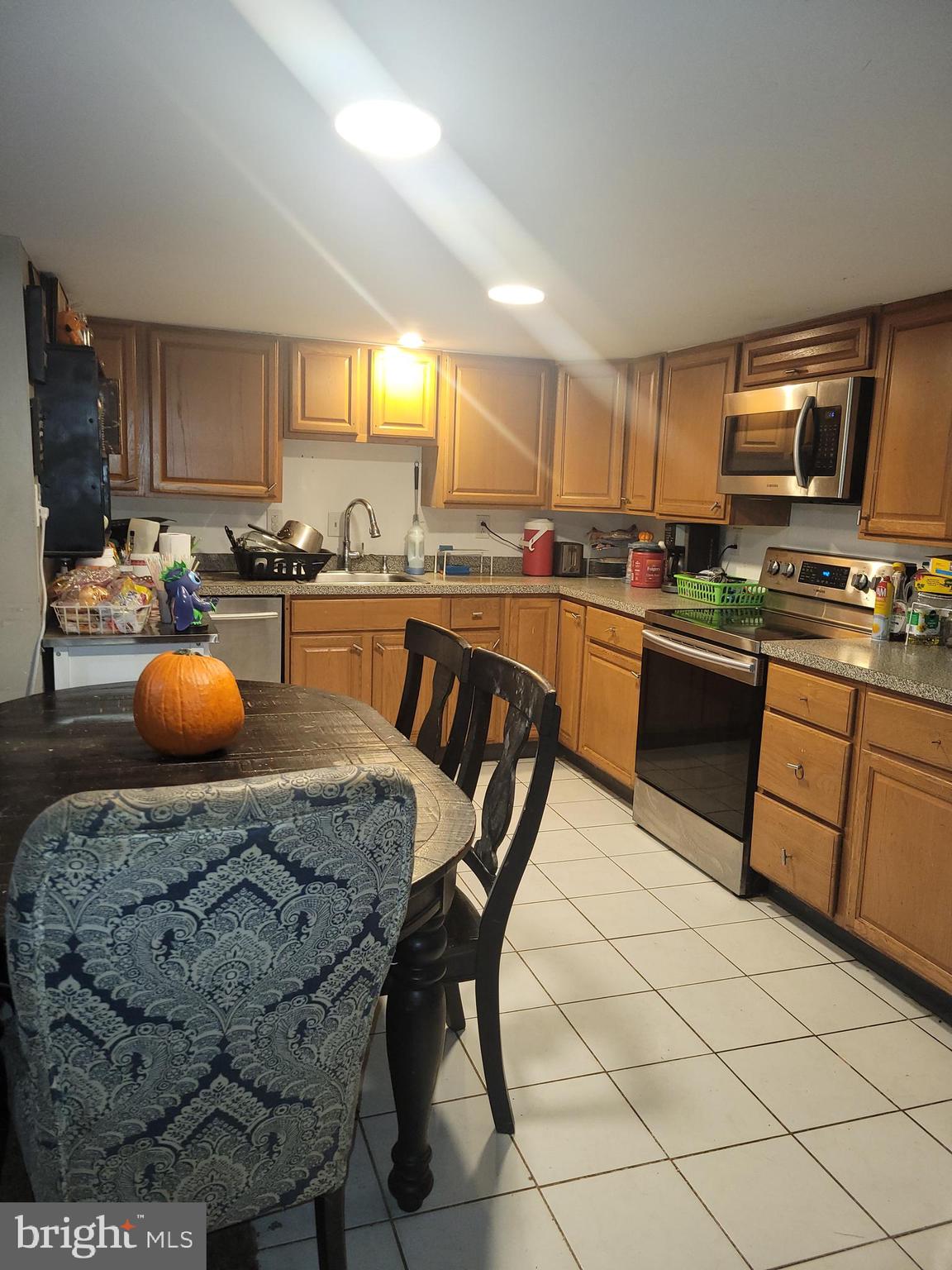 1476 Zebley Road Garnet Valley, PA 19060 - Photo 2 of 15 a kitchen with stainless steel appliances granite countertop a stove a sink dishwasher a dining table and chairs with wooden floor