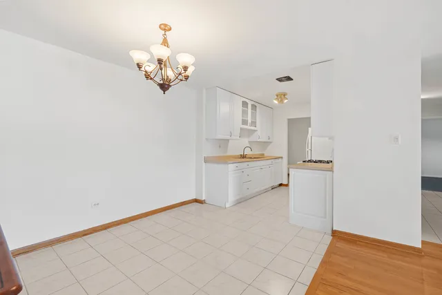 a kitchen that has a lot of white cabinets and wooden floor