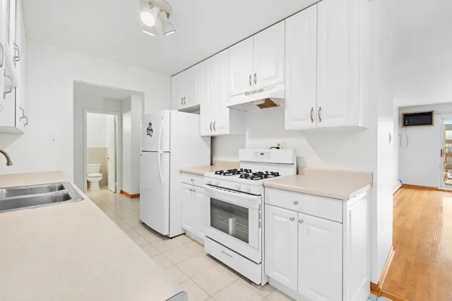a kitchen with white cabinets and white appliances