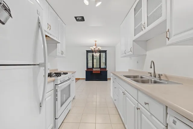 a large kitchen with granite countertop a sink and a stove top oven