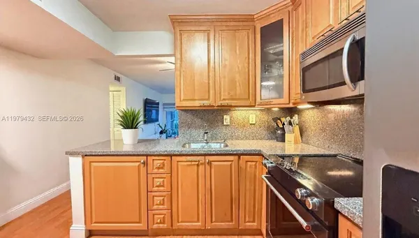 a kitchen with stainless steel appliances granite countertop a sink and a cabinets