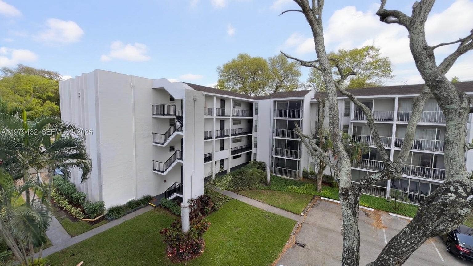 483 North Pine Island Road, Unit C205 Plantation, FL 33324 - Photo 21 of 22 a view of a house with a yard and a large tree