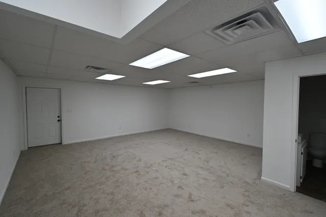 a view of an empty room with a ceiling fan and a fireplace