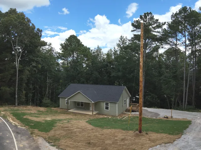 a front view of a house with a yard and tree s