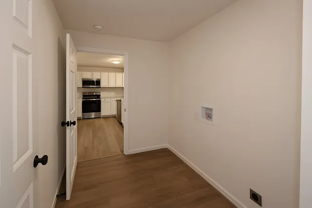 a view of empty room with wooden floor