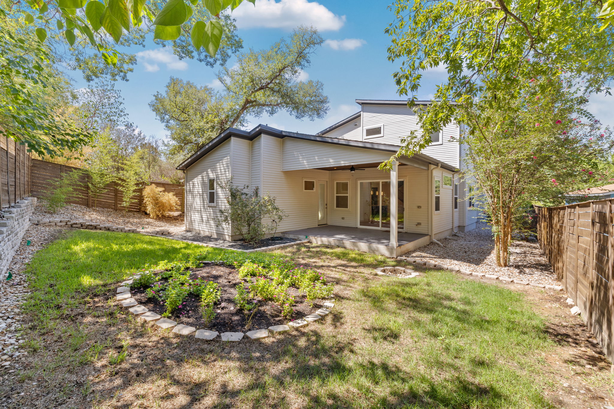 1719 Bunche Road Austin, TX 78721 - Photo 31 of 36 Mature trees frame a private backyard complete with a covered patio and garden beds.