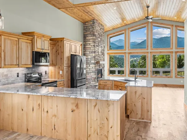 a kitchen with granite countertop a stove a sink and a refrigerator