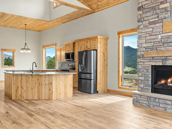 a kitchen with stainless steel appliances a refrigerator and a fireplace