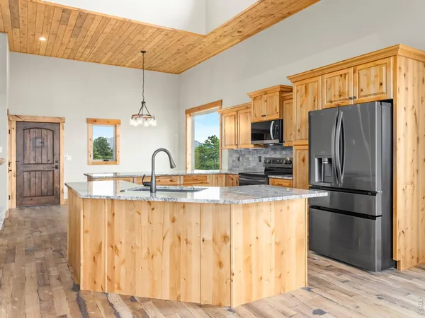 a kitchen with granite countertop a refrigerator and a stove top oven