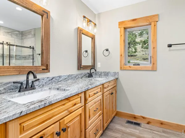 a bathroom with a granite countertop sink and a mirror