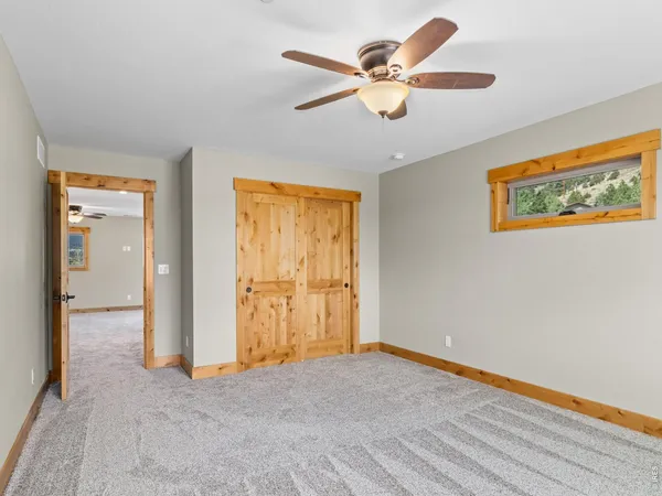 an empty room with a ceiling fan and a window