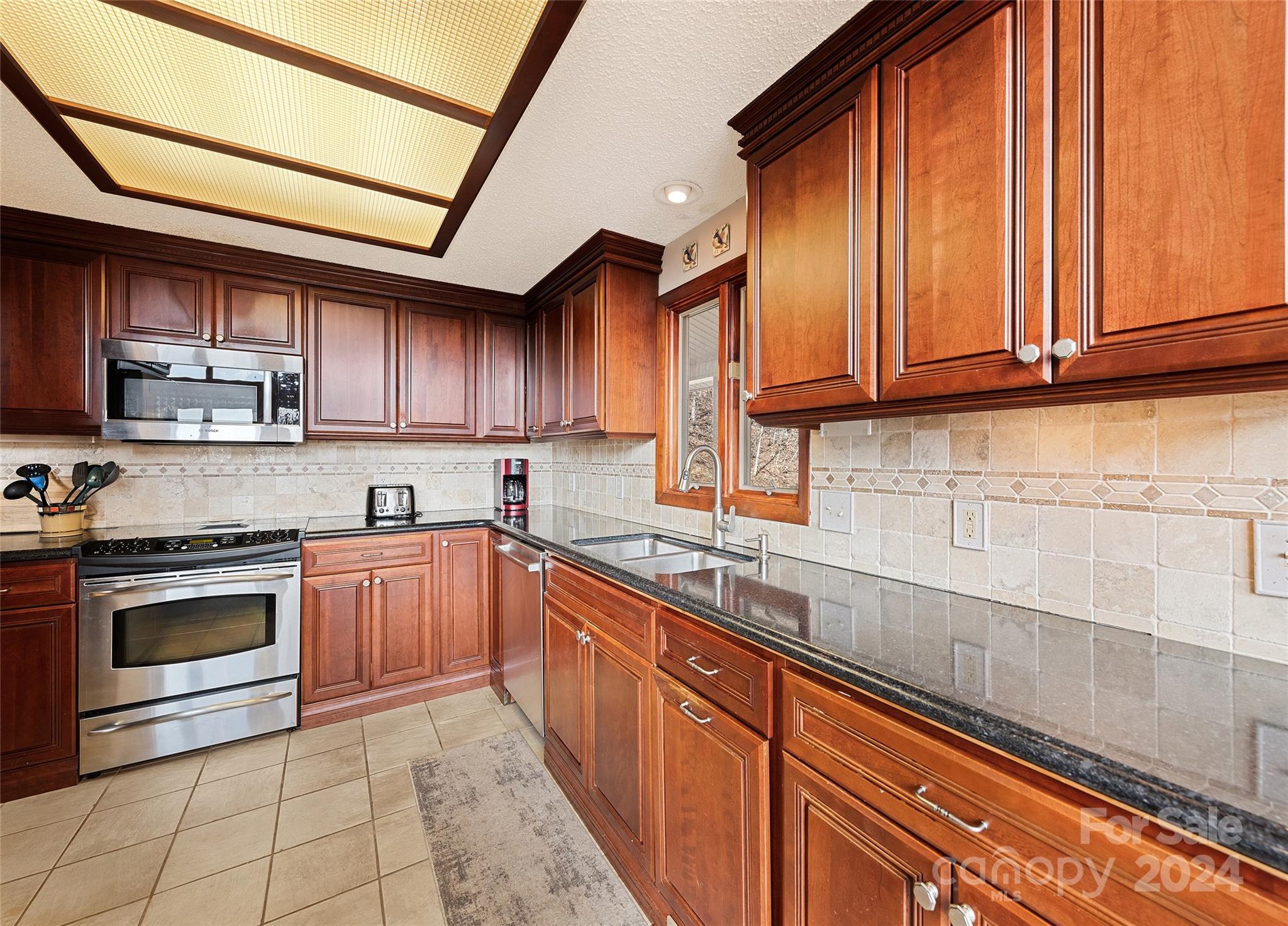 2521 Pless Underwood Road Maggie Valley, NC 28751 - Photo 13 of 46 a kitchen with stainless steel appliances granite countertop a sink a stove and cabinets