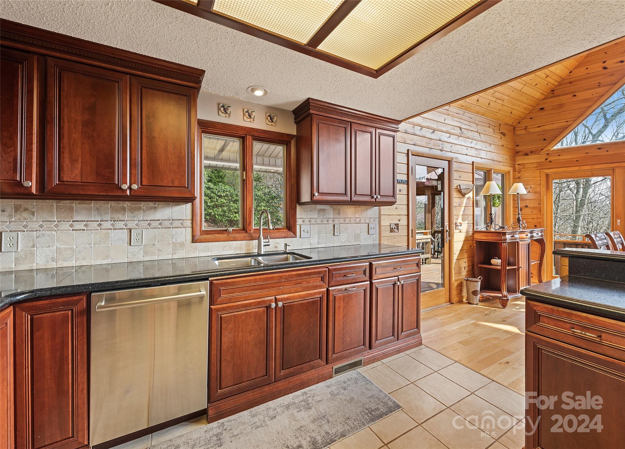 2521 Pless Underwood Road Maggie Valley, NC 28751 - Photo 14 of 46 a kitchen with stainless steel appliances granite countertop wooden cabinets a sink and dishwasher with a large window