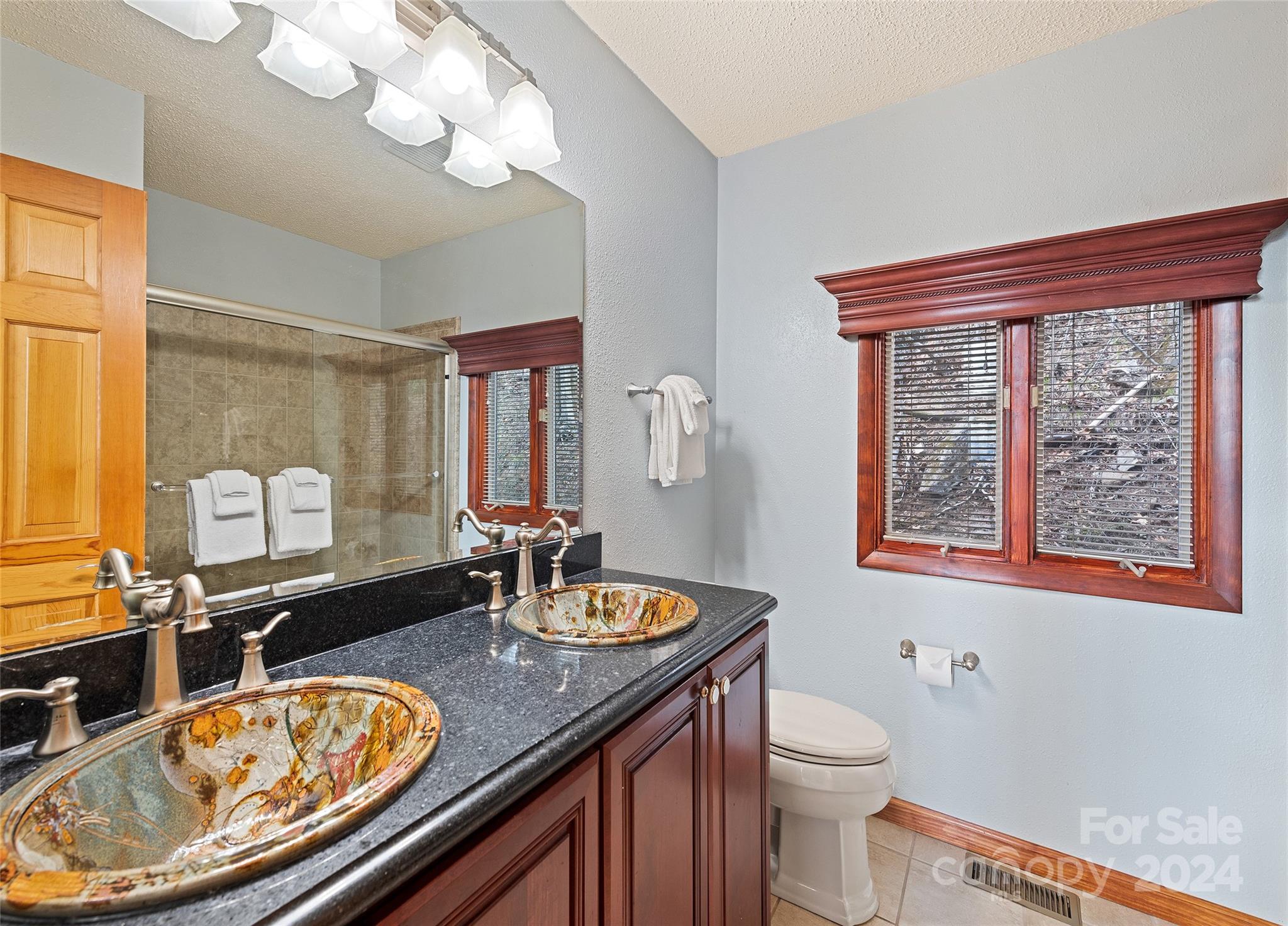 2521 Pless Underwood Road Maggie Valley, NC 28751 - Photo 19 of 46 a bathroom with a granite countertop toilet a sink and a mirror