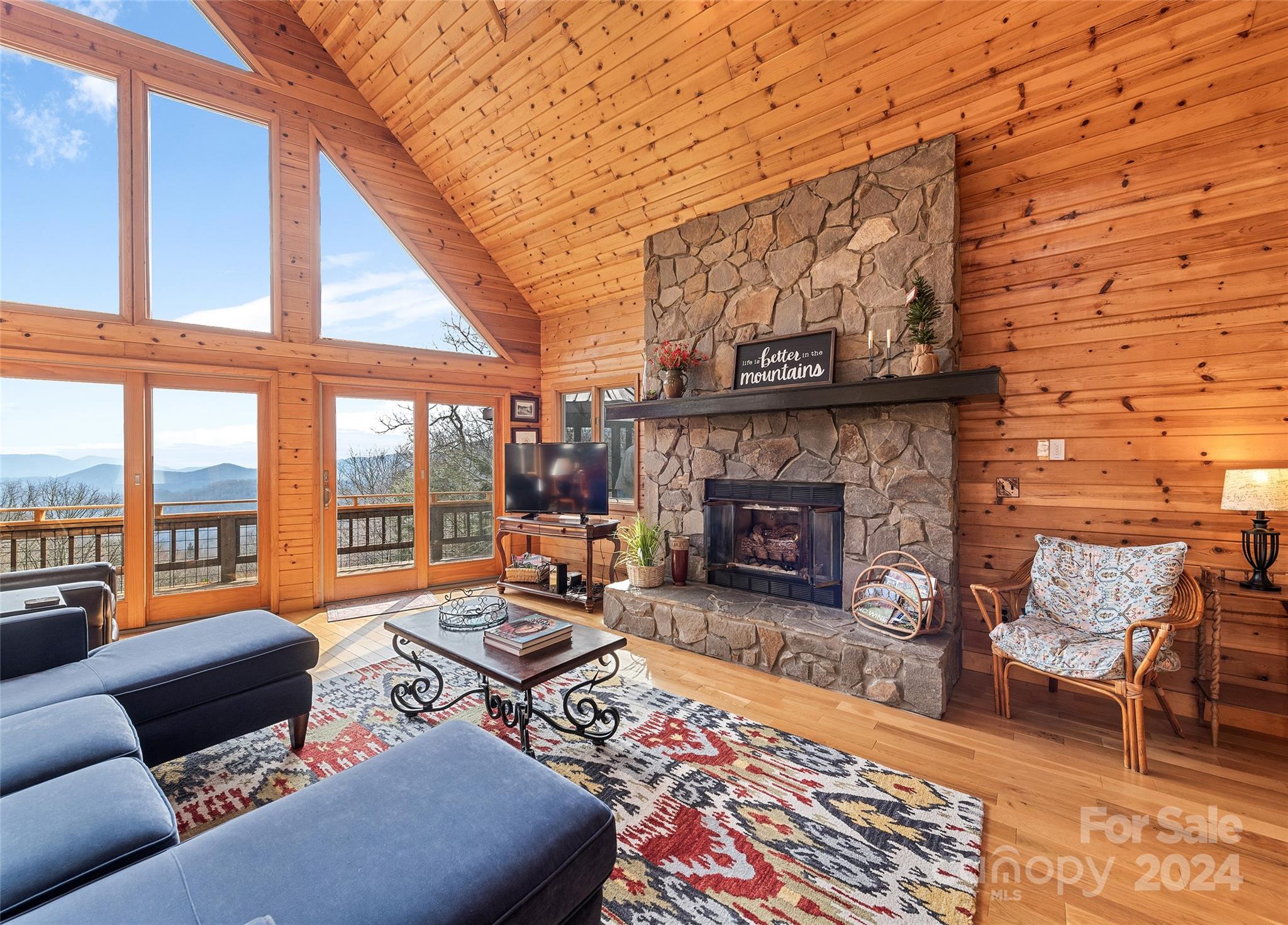 2521 Pless Underwood Road Maggie Valley, NC 28751 - Photo 8 of 46 a living room with furniture a fireplace and a floor to ceiling window