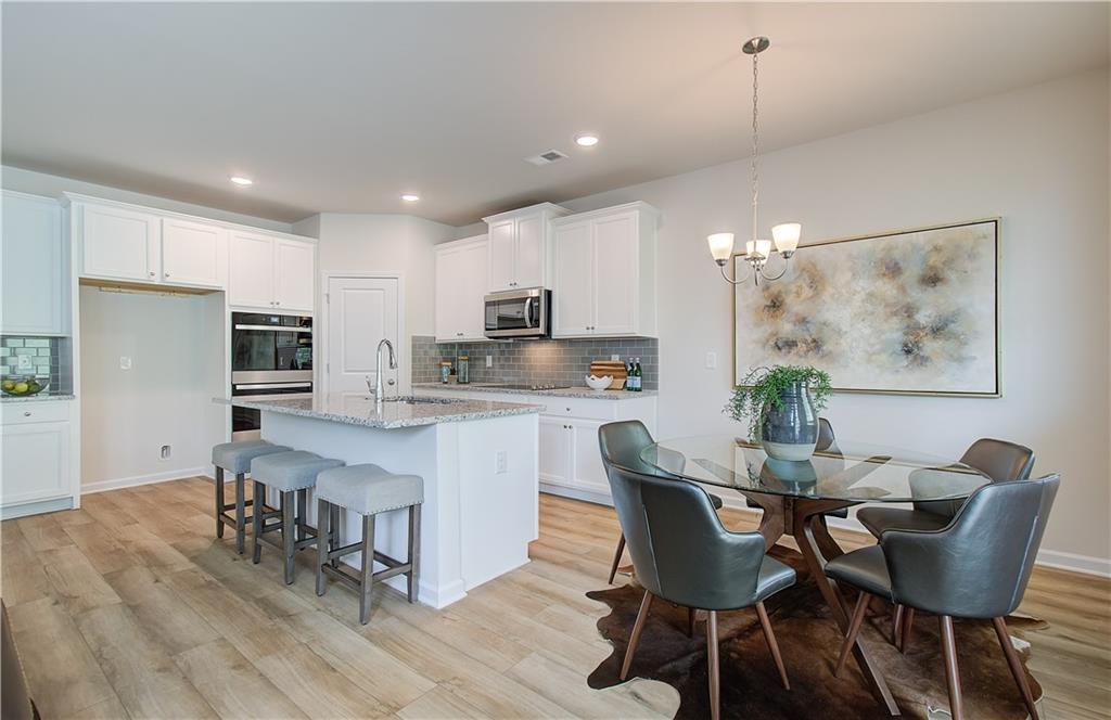 467 Collier Mls Road Lawrenceville, GA 30045 - Photo 18 of 39 a view of a dining room with furniture and wooden floor