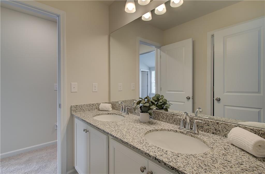 467 Collier Mls Road Lawrenceville, GA 30045 - Photo 27 of 39 a bathroom with a granite countertop double vanity sink and a mirror