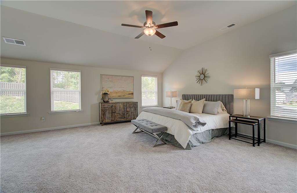 467 Collier Mls Road Lawrenceville, GA 30045 - Photo 30 of 39 a spacious bedroom with a bed a window and a chandelier