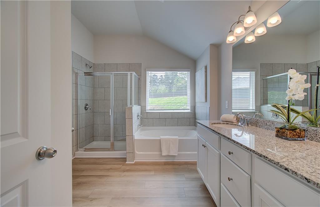 467 Collier Mls Road Lawrenceville, GA 30045 - Photo 35 of 39 a bathroom with a granite countertop sink a large mirror and a shower