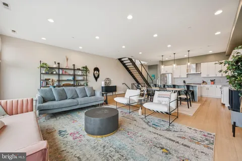a living room with furniture and a wooden floor