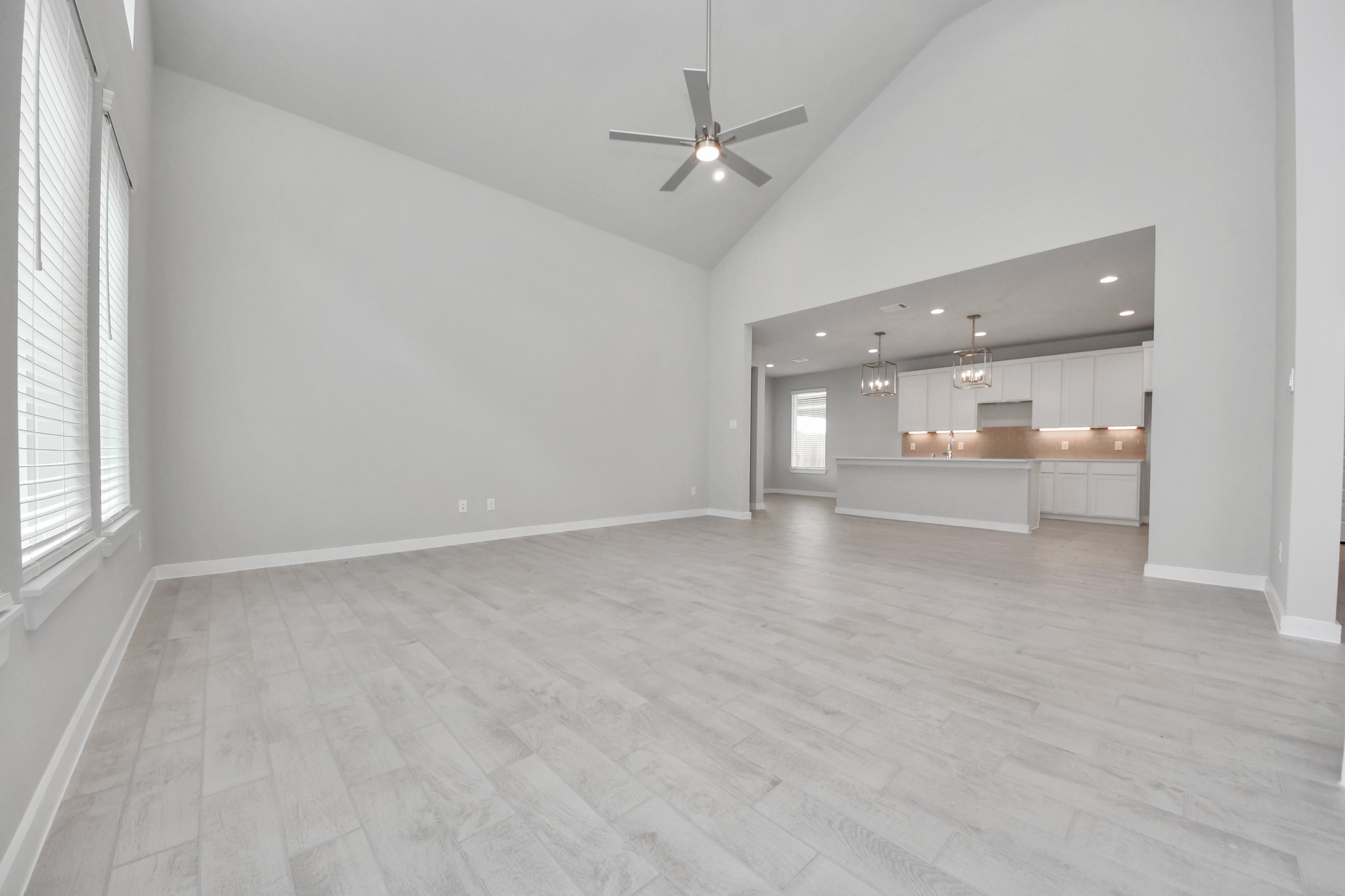11114 Tulip Rdg Trail Houston, TX 77044 - Photo 16 of 30 Relax and unwind in this inviting family room, illuminated by abundant natural light streaming in through tall windows, complemented by high ceilings and stunning flooring. Stay comfortable year-round with the gentle breeze from the ceiling fan, creating the perfect atmosphere for family gatherings. Sample photo of completed home with similar floor plan. Actual colors and selections may vary.