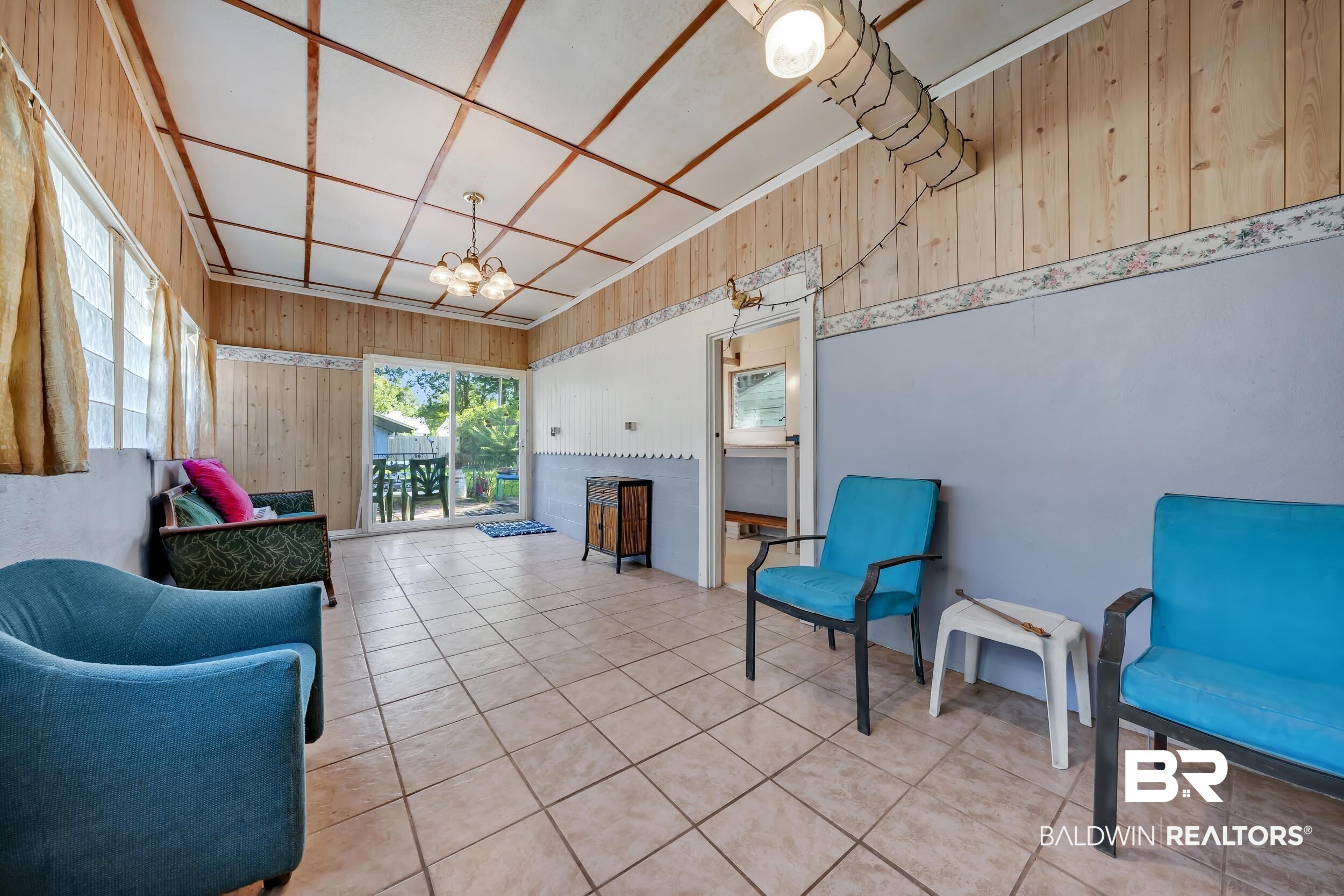 304 West Myrtle Avenue Foley, AL 36535 - Photo 17 of 29 Tiled flooring extends across this room, featuring wood paneling on the upper walls and a white ceiling with exposed wood beams