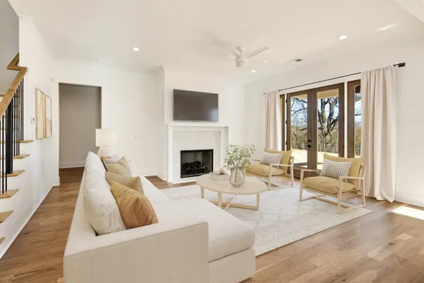 a living room with furniture white walls and kitchen view